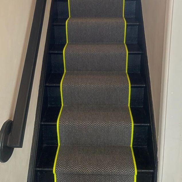 black and white herringbone carpet stair runner with neon yellow edging on black stairs